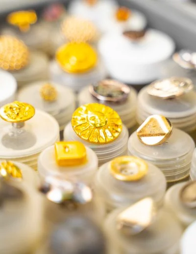 Goldene und silberne Zierknöpfe auf Präsentationsständern